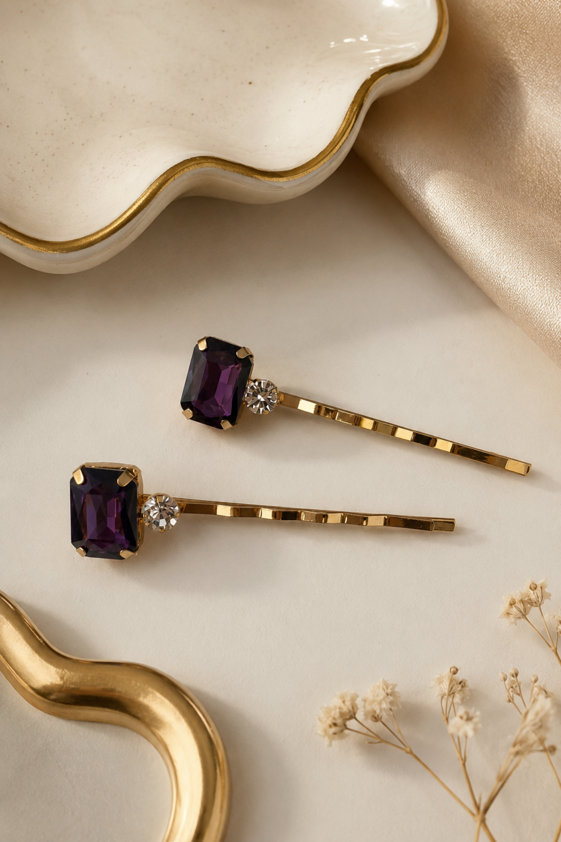 Set of two purple crystal and rhinestone gold hair slides for women, featuring rectangular amethyst-style gemstones on slim gold bobby pins, elegant statement hair accessories for weddings, parties and evening outfits.