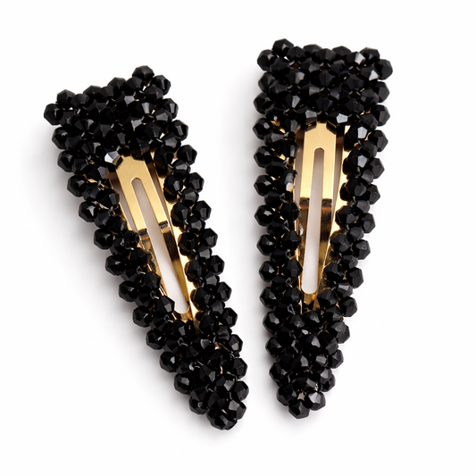 Pair of black beaded hair clips on a white background