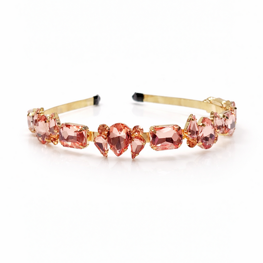 Gold headband with pink gemstones on a white background