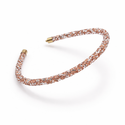 Rose gold headband with glittery stones on a white background