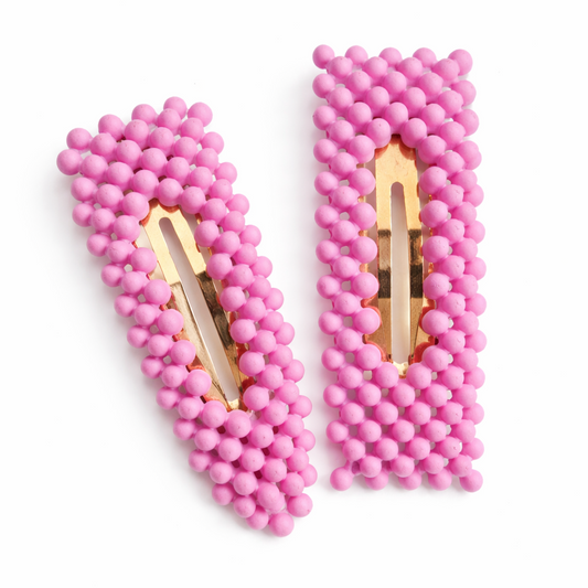 Pair of pink beaded hair clips on a white background