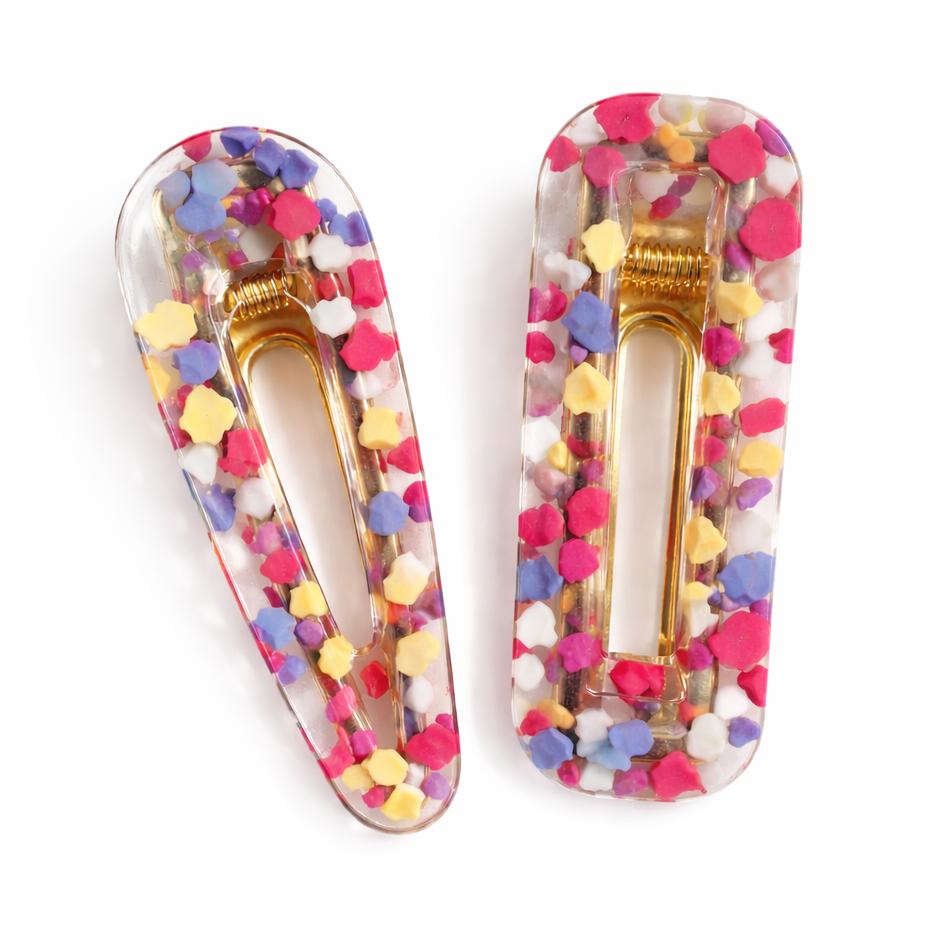 Colorful hair clips with heart-shaped embellishments on a white background
