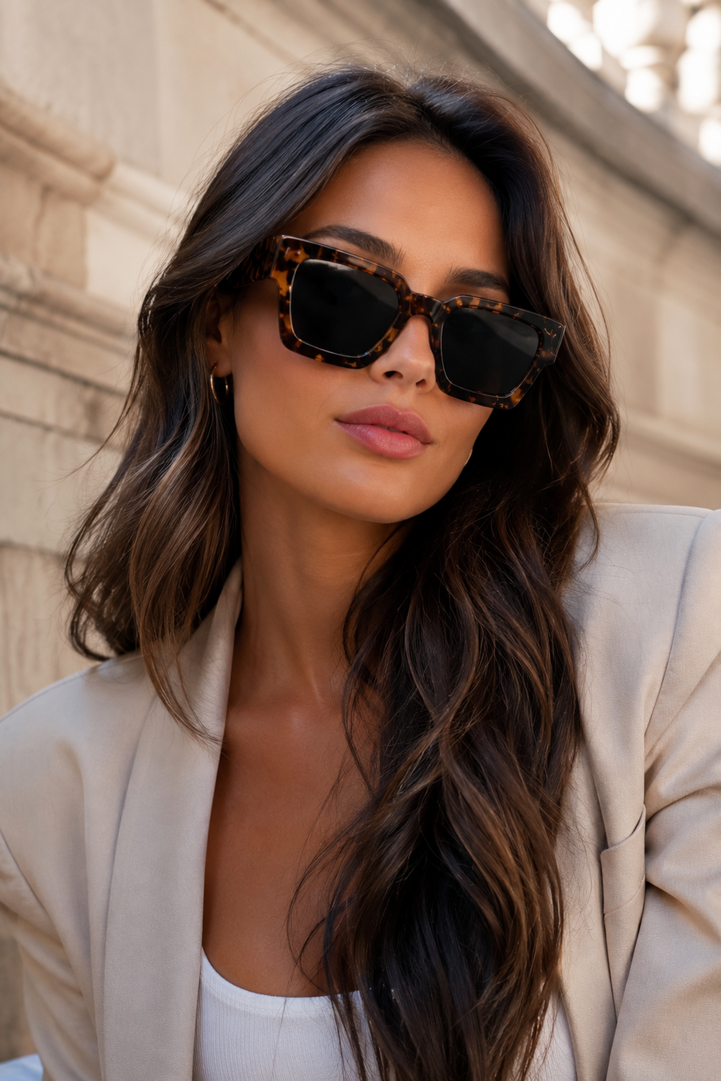 Woman wearing sunglasses with a neutral background