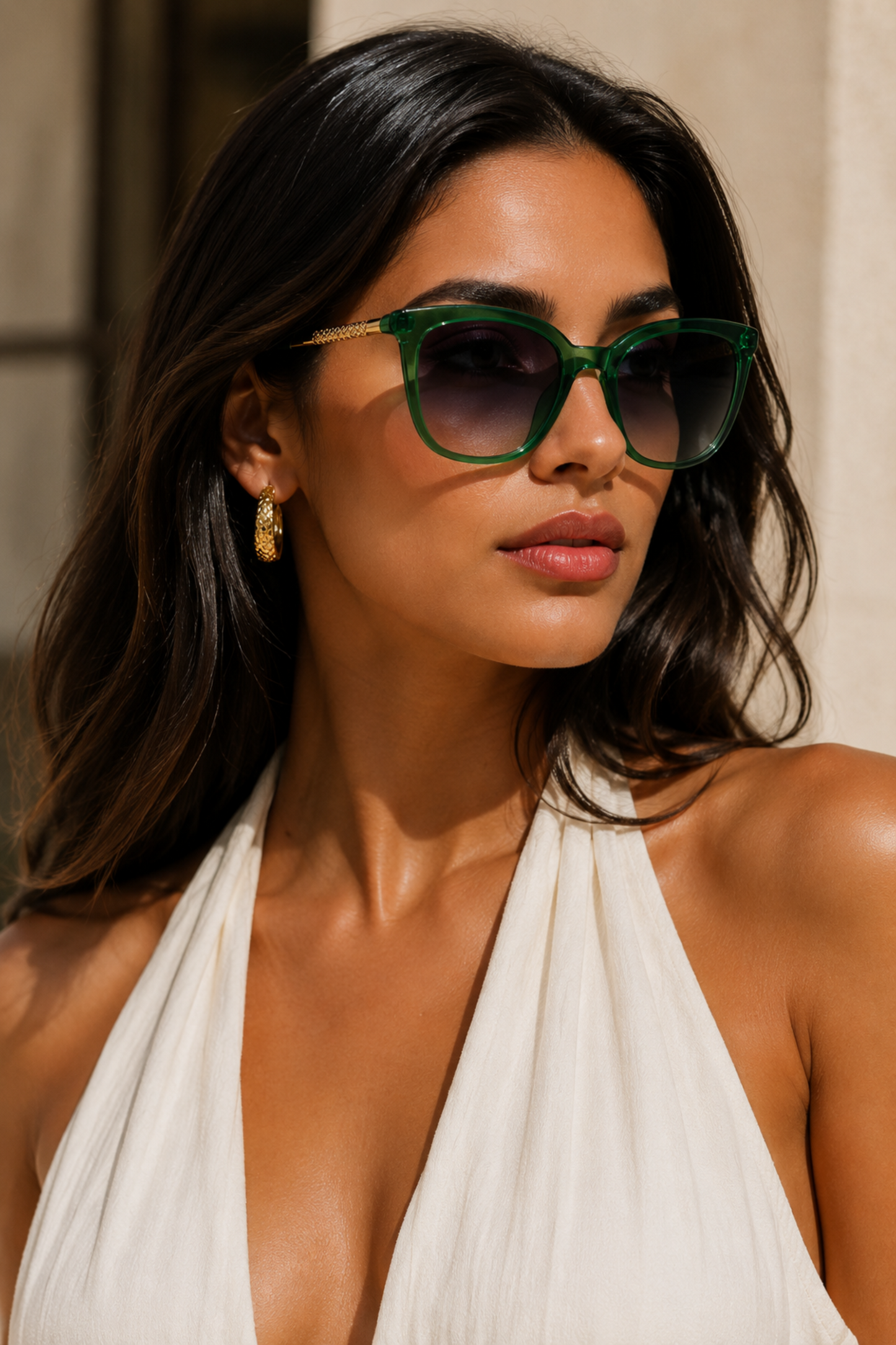Woman wearing green sunglasses and a white halter top outdoors.